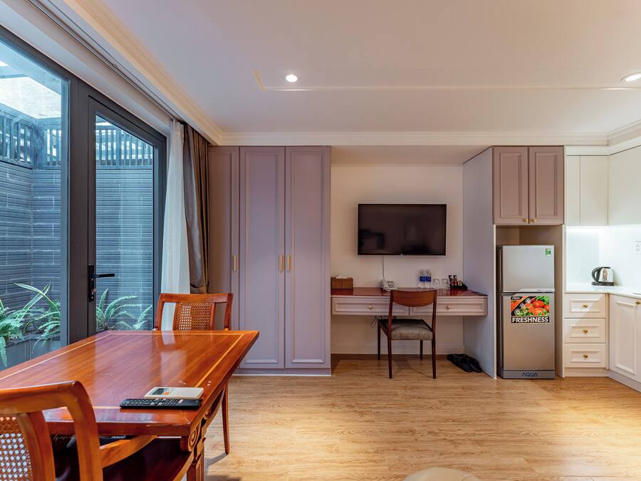 Una cocina moderna con comedor, televisor de pantalla plana y refrigerador.