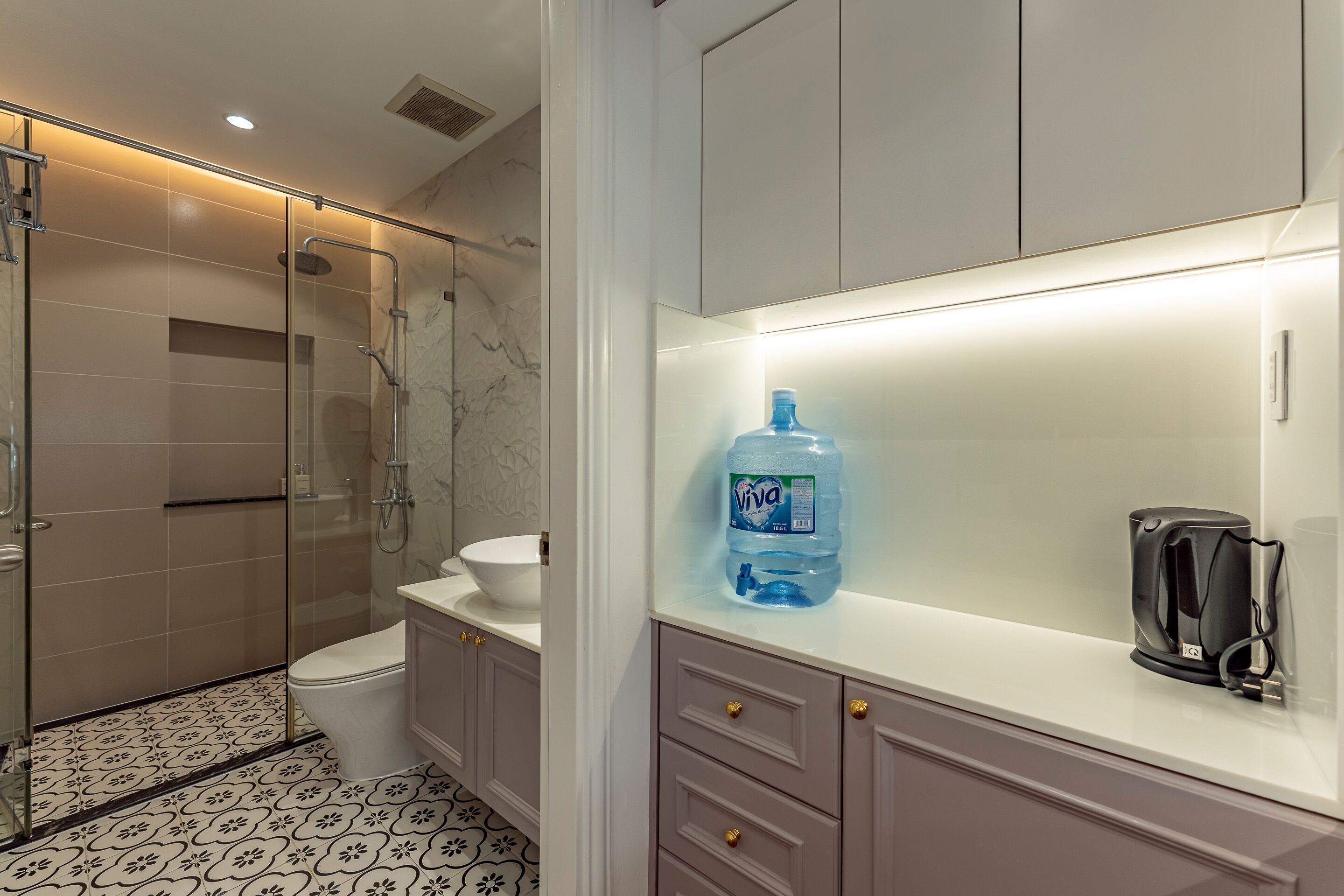 Een badkamer met een douche, toilet en een groot waterreservoir op het aanrecht.