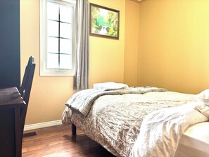 A bedroom with a bed, a chair, a window with curtains, and a framed picture on the wall. - Quiet Room Around York University Subway (Toronto)