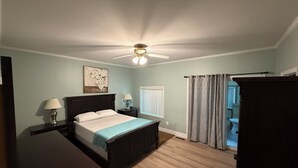 A bedroom with a bed, two bedside tables with lamps, a ceiling fan, a window with blinds, and a door leading to another room. - Quiet neighborhood/ pets friendly? fenced in / close to beach (Rehoboth Beach)