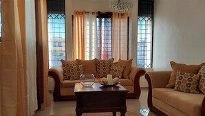 A living room with two sofas, a coffee table, and a chandelier.