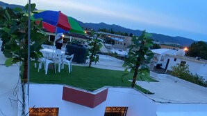A modern outdoor patio area with a seating arrangement and a view of the surrounding neighborhood.