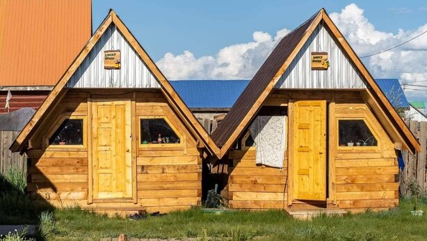 Two wooden cabins with pitched roofs, each featuring a window and a door. - Mountain View Guesthouse (Moron)
