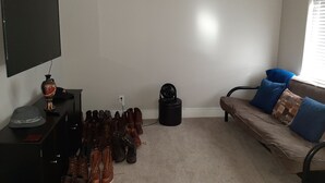 A living room with a TV, a sofa with blue cushions, a coffee table, and a shoe rack filled with various shoes. - Beautiful home close to the Eugene Airport with easy access to downtown Eugene (Eugene)