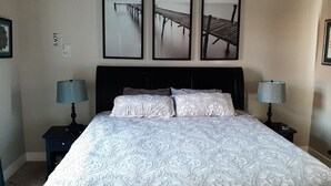 A neatly made bed with patterned bedding, two bedside tables with lamps, and three framed pictures of a pier on the wall. - Beautiful home close to the Eugene Airport with easy access to downtown Eugene (Eugene)