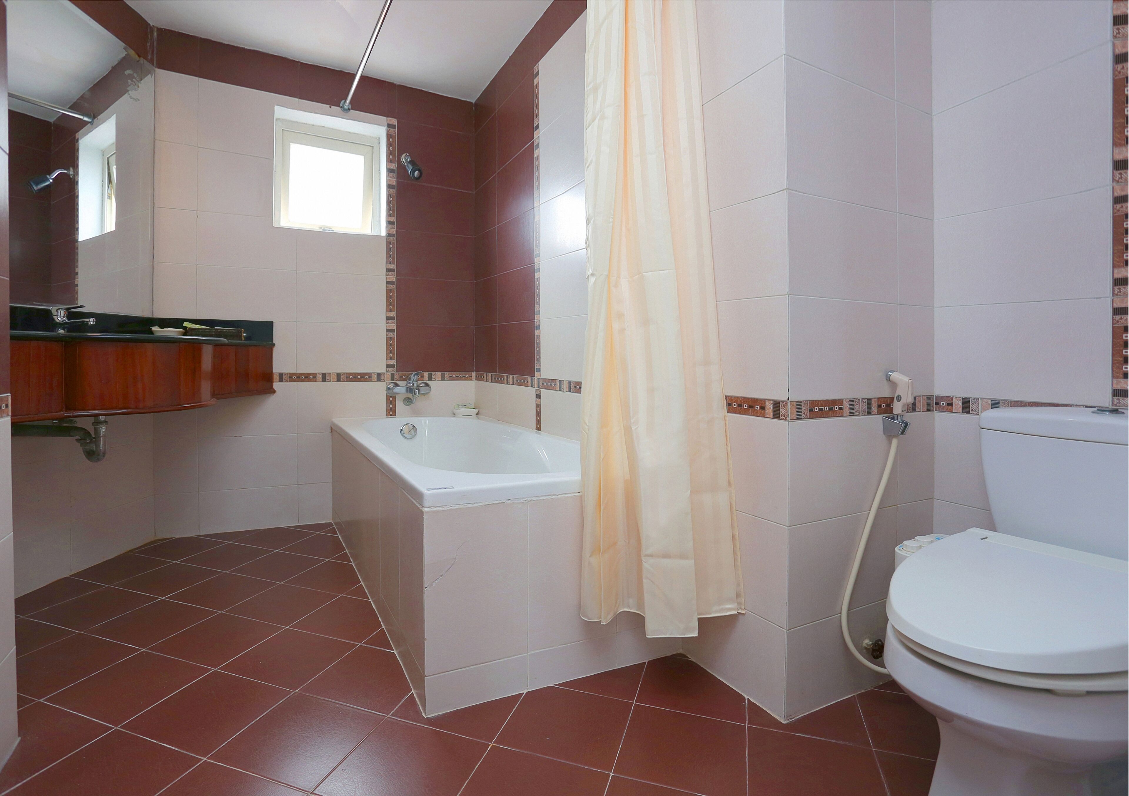A bathroom with a bathtub, toilet, and a shower curtain.