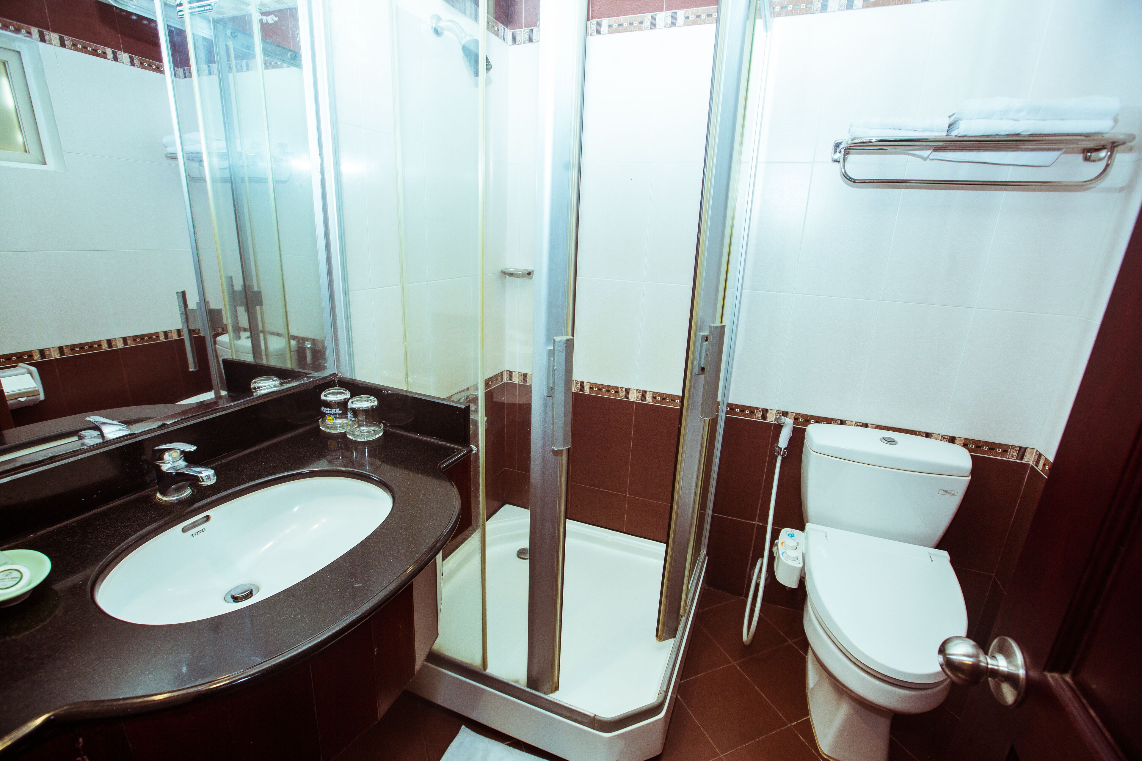 A bathroom with a sink, toilet, and glass-enclosed shower.