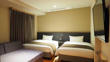 A hotel room with two beds, a sofa, a TV, and a curtain.