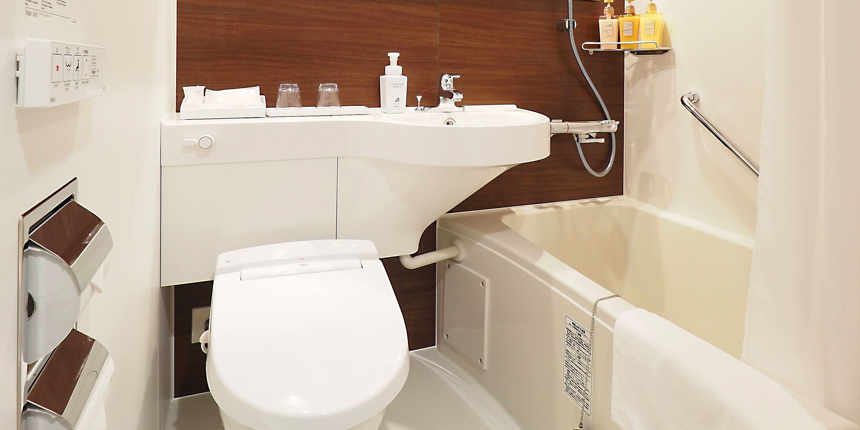 A modern bathroom with a toilet, sink, and bathtub.