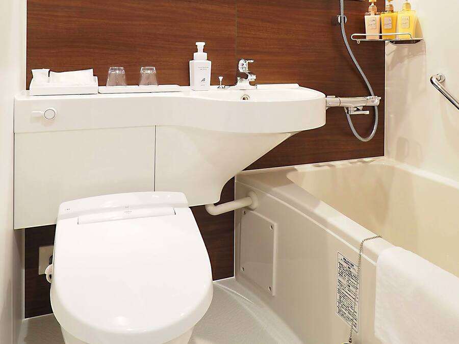 A modern bathroom with a toilet, sink, and bathtub.