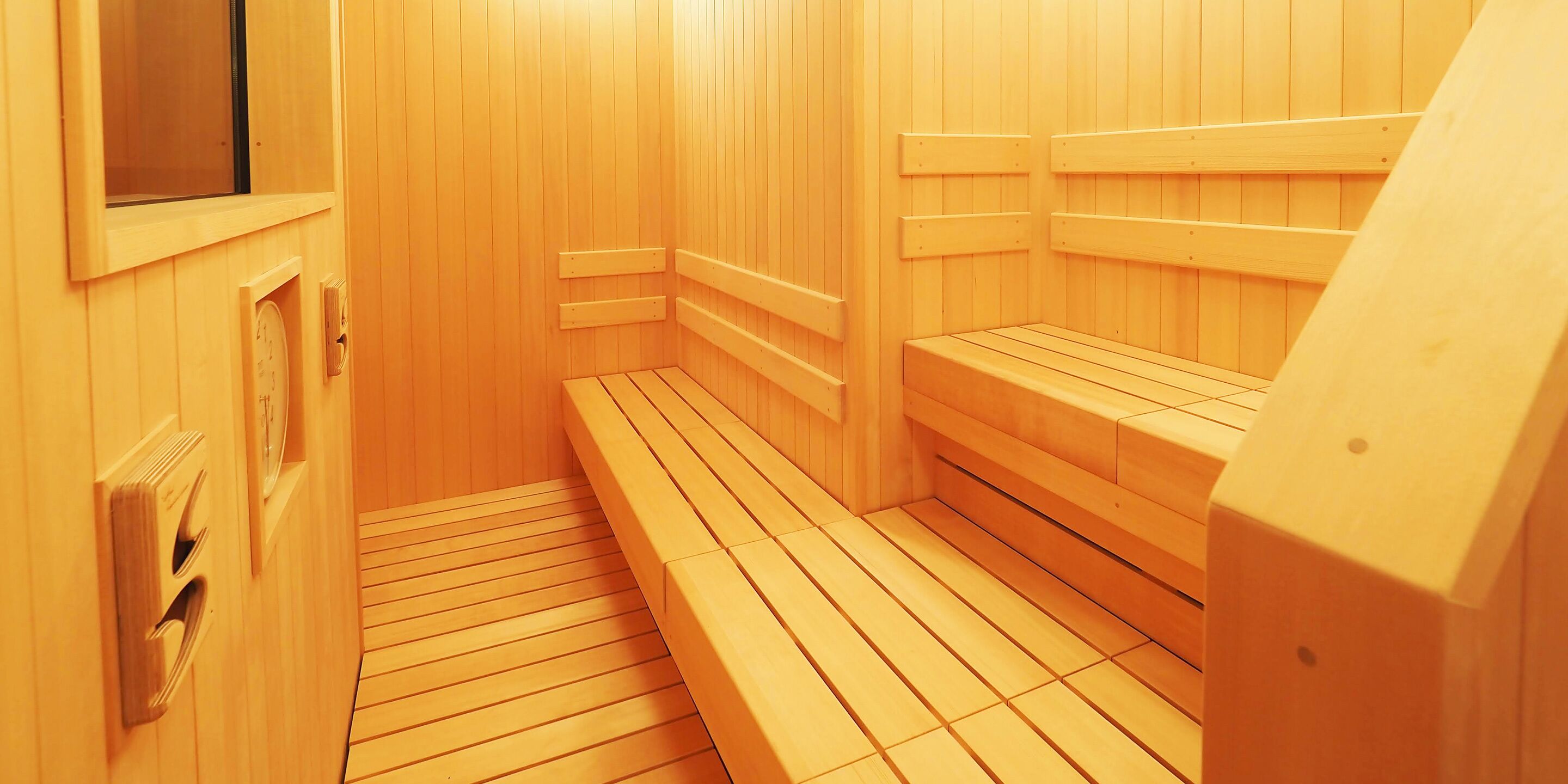 A sauna with wooden benches and a tiled floor.