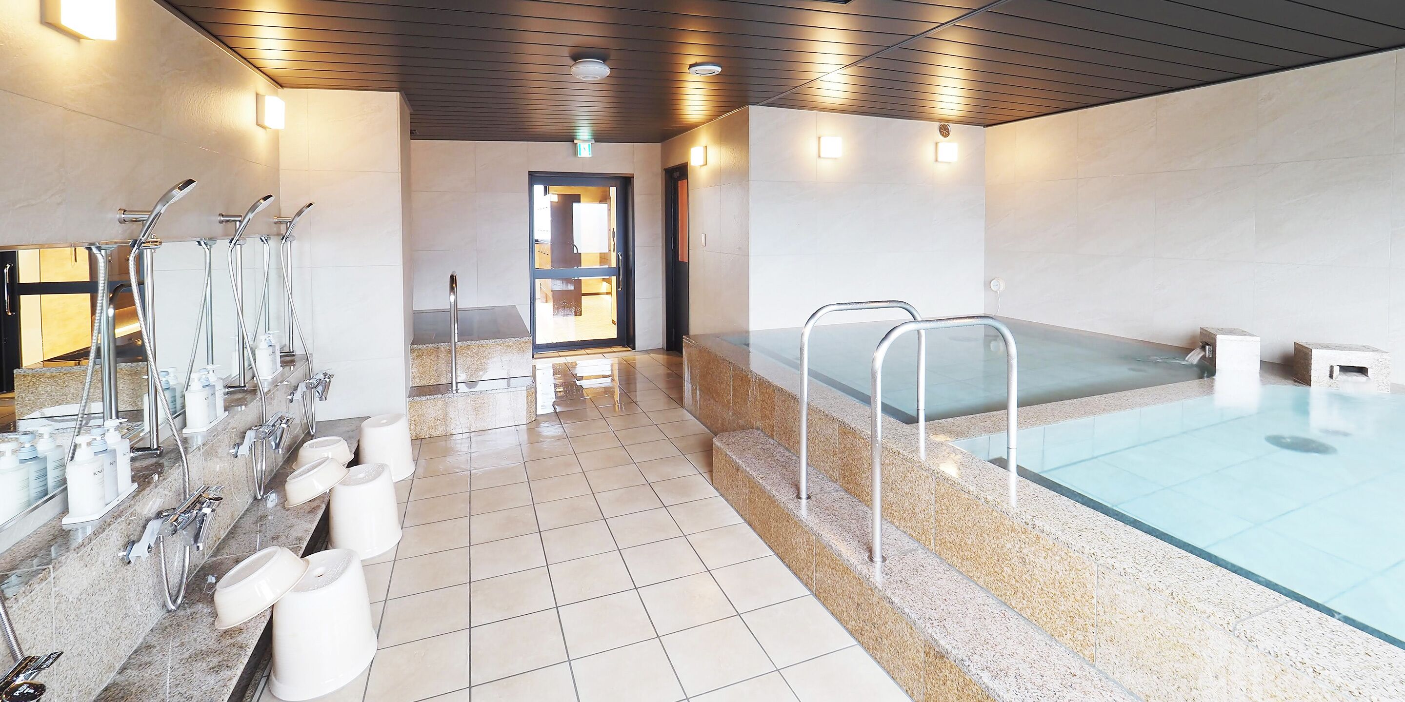A modern bathroom with multiple sinks, a large bathtub, and a tiled floor.