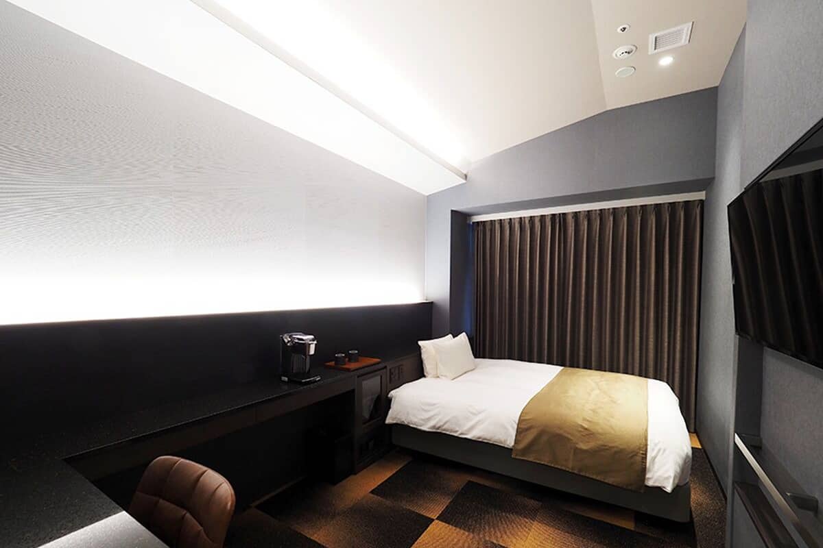 Una habitación de hotel moderna con cama, escritorio y silla.