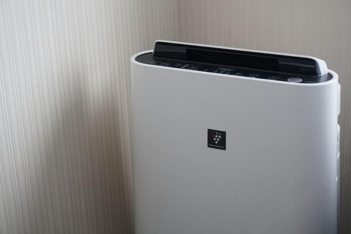 Un equipo de aire acondicionado blanco y moderno, fijado a la pared, con un panel de control y un pequeño logo en la parte frontal.