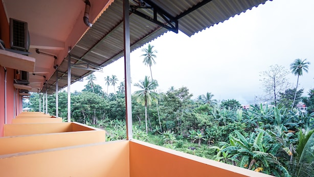 A covered outdoor area with a series of steps leading down to a lush, green landscape. - OYO 2486 Bahana Guest House (Manado)