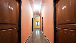 A corridor with wooden doors, each marked with a number. - OYO 2486 Bahana Guest House (Manado)