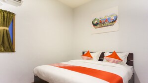 Uma cama bem arrumada com roupa de cama branca e laranja, um quadro na parede e uma janela com cortinas verdes.