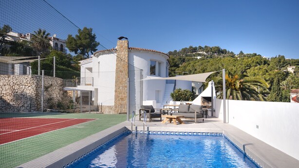 A swimming pool with a tennis court, outdoor seating, and a stone wall. - Sara 6 P.- modern, family friendly, with private pool and private tennis court! (Benissa)