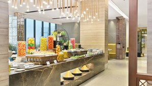 Uma área de buffet com diversas opções de comida e um balcão de mármore.