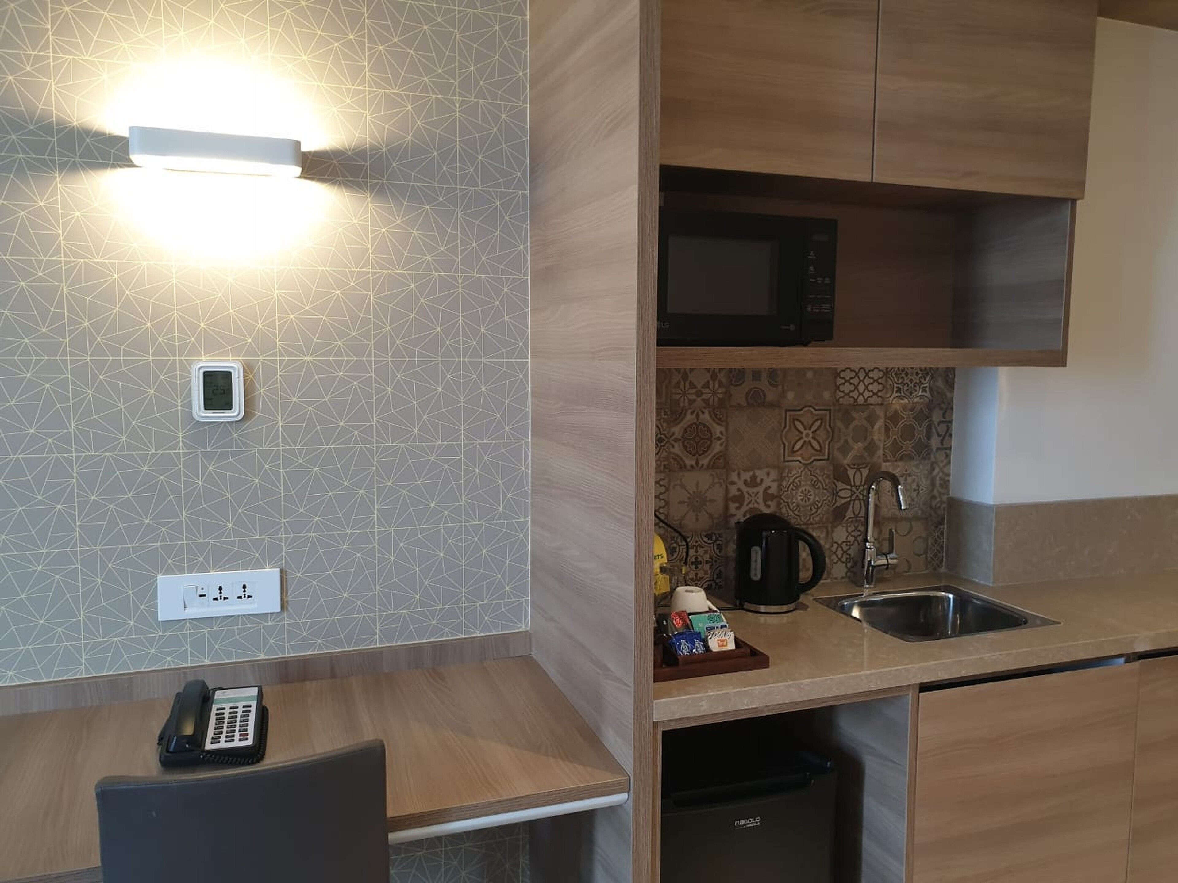 A modern kitchen with a microwave, sink, and a coffee maker on the countertop.