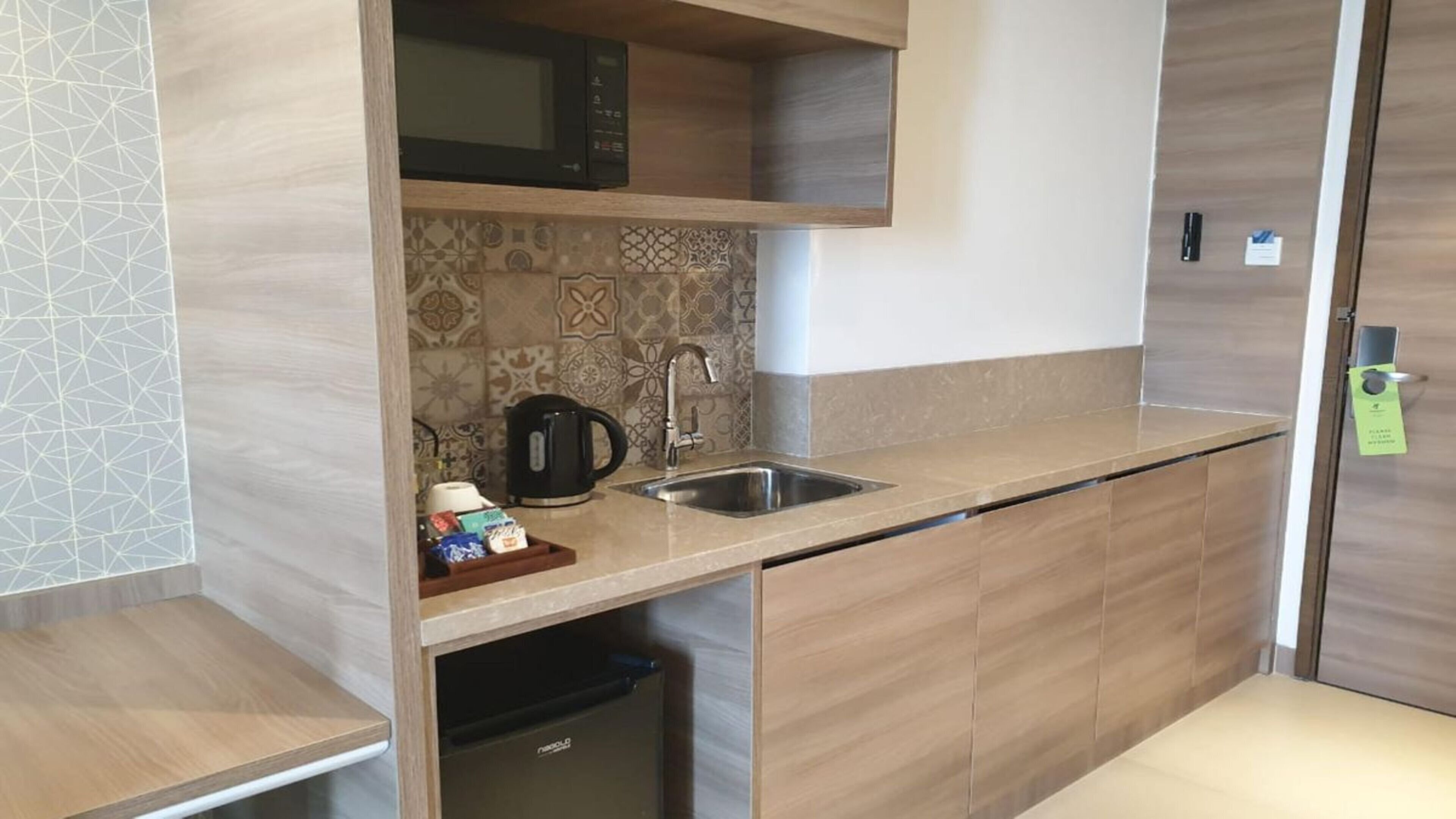 A compact kitchen with a microwave, sink, and coffee maker.
