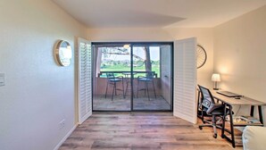 Une pièce dotée d’une porte-fenêtre coulissante donnant sur un patio extérieur avec une table et des chaises.