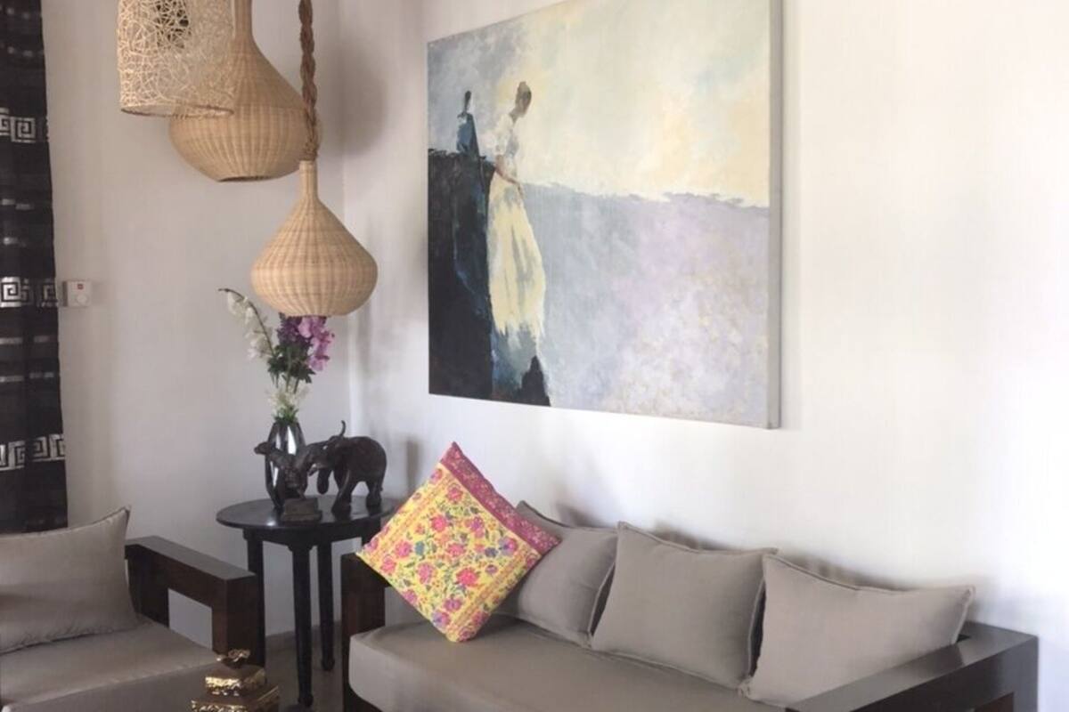 Una sala de estar con un sofá, una mesita de centro y un cuadro en la pared.