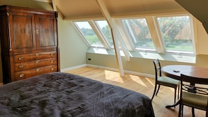 Ein Schlafzimmer mit Oberlicht, Holzmöbeln und Blick ins Freie.