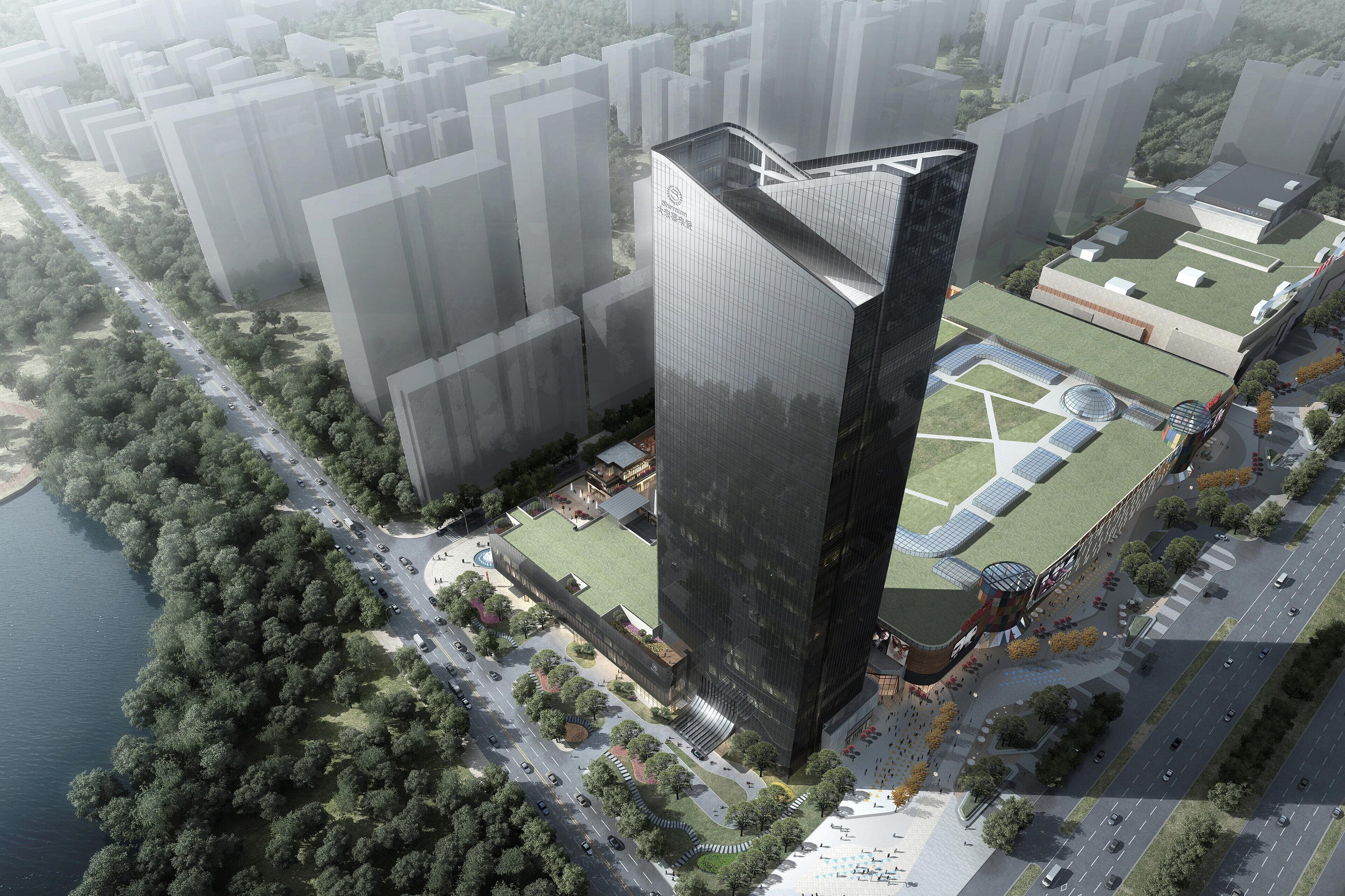 Un immeuble moderne de grande hauteur, doté d’un sommet triangulaire original, entouré d’un espace paysager agrémenté d’arbres et bordé d’une route.