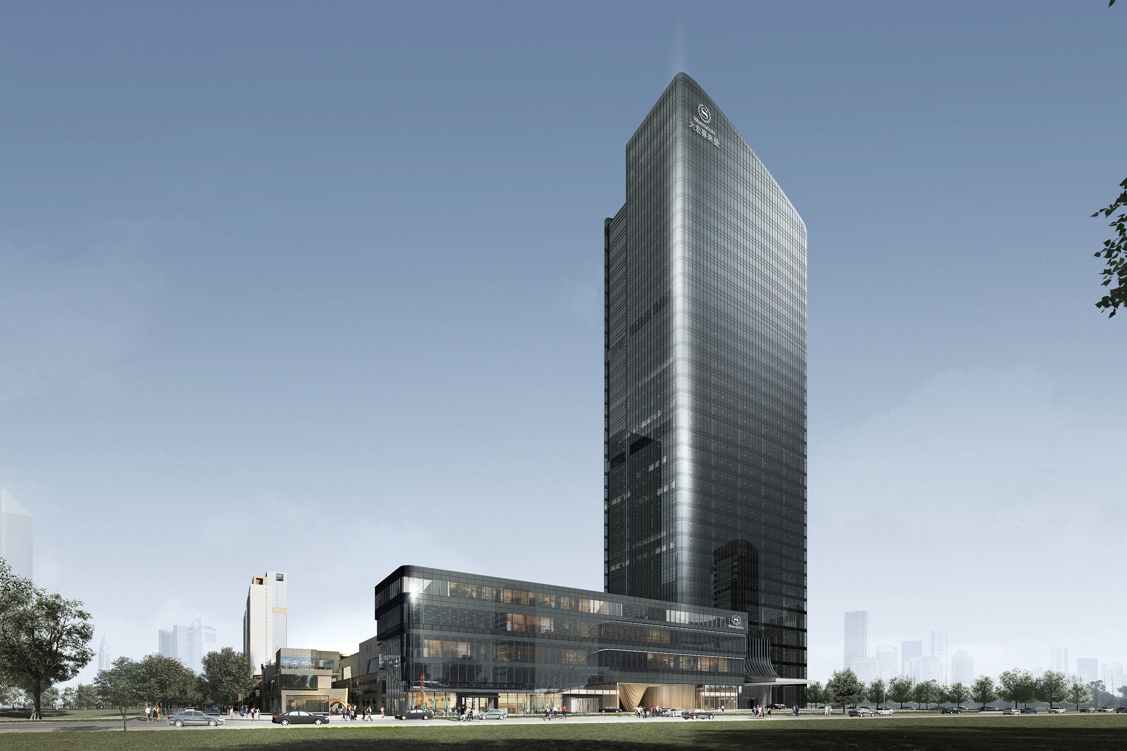 Un moderno edificio de gran altura con fachada de vidrio reflectante, rodeado por un parque con árboles y un cielo despejado.