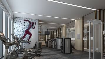 A modern gym with exercise equipment, a large digital screen, and a motivational artwork on the wall.