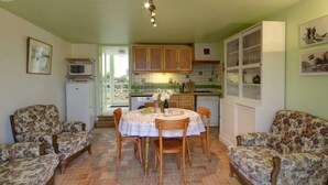 Een gezellige keuken met een eettafel, stoelen en een koelkast.