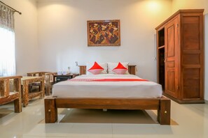 Un dormitorio ordenado con una cama de madera, una mesita de noche, una lámpara y un armario.