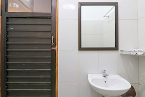 A bathroom with a white sink, a mirror, and a toilet. - OYO 2607 Men Bebas Residence (Ubud)
