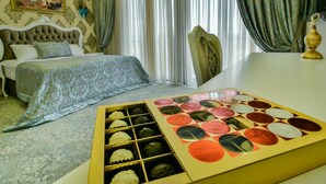 A hotel room with a large bed, a chest of drawers, and a decorative box of chocolates. - Basilica GuestHouse (Istanbul)