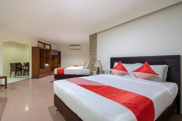 A hotel room with a large bed, a smaller bed, a wardrobe, a desk, and a chair. - Flagship 2688 Guntur Hotel (Denpasar)