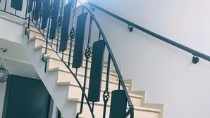 A staircase with black metal railings and beige steps. - Lodge Rose's Heart (Bad Kleinkirchheim)