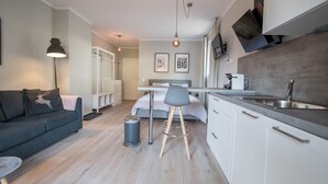 A modern, compact living space with a kitchenette, a dining area, and a bedroom. - Lodge Rose's Heart (Bad Kleinkirchheim)