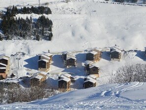 A snow-covered village with multiple chalet-style buildings. - Comfort Duplex for 4 in Les Menuires, 50m from slopes, baby-friendly (Les Menuires)