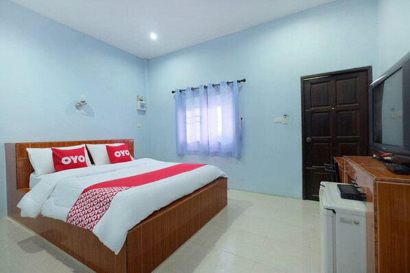 Quarto com cama, televisão, máquina de lavar e porta.