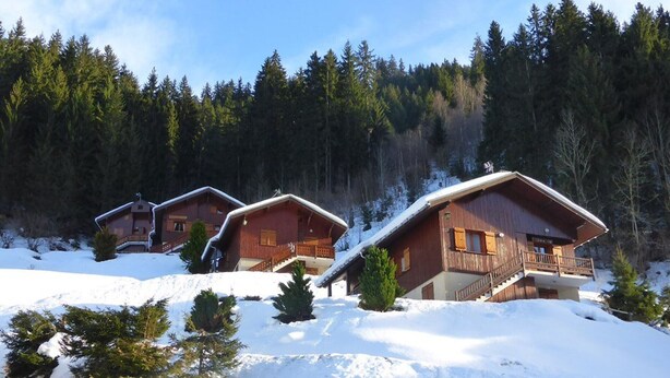 A cluster of wooden cabins with balconies, surrounded by snow and forest. - Cozy 1BR with terrace in Arêches, sleeps 4, near slopes and shuttle (Arêches-Beaufort)