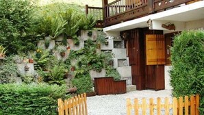A building with a stone facade, wooden balcony, and a gravel pathway leading to a wooden gate. - Cozy 1BR with terrace in Arêches, sleeps 4, near slopes and shuttle (Arêches-Beaufort)