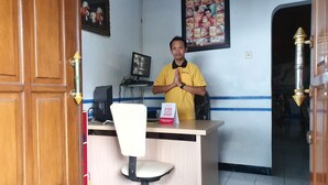 A reception desk with a computer, a chair, and a framed picture on the wall. - OYO 2302 Blue House Costel Syariah (Cianjur)