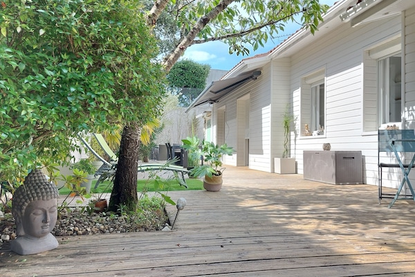 Terrasse en bois entourée de verdure..