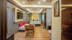 A modern hotel room with a bed, a desk, a chair, and a ceiling fan. - Castle Blue By Excellent Hospitality (New Delhi)
