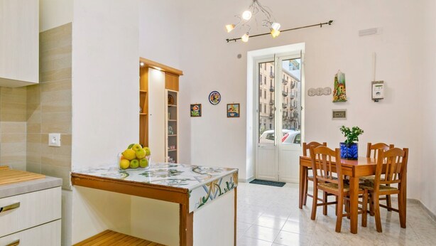 Una cocina con comedor, una mesa de madera y vistas a través de un ventanal.