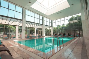 Una piscina techada, una piscina al aire libre de temporada, sombrillas