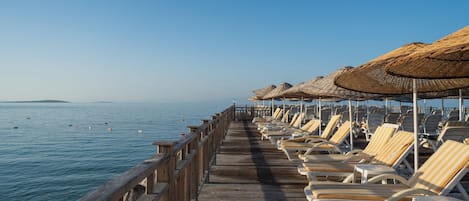 Playa privada, sillas reclinables de playa, sombrillas, toallas de playa