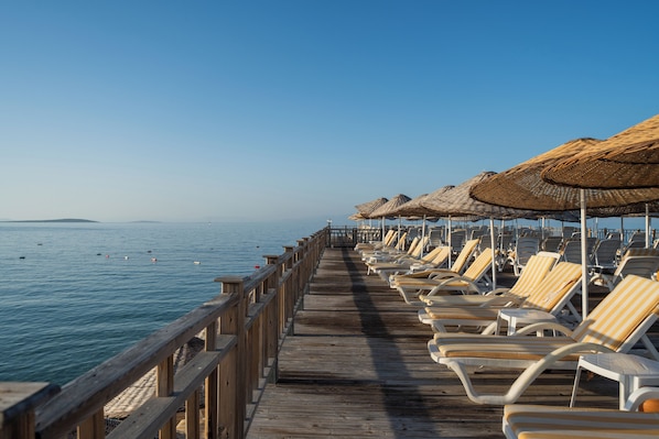 Privat strand, solstolar, parasoller och strandhanddukar