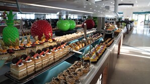 Um buffet com diversos doces e frutas.